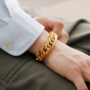Men's vacuum plated gold titanium steel Cuban link bracelet worn on a model's wrist