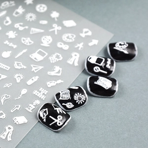White 3D embossed school theme nail art stickers featuring books and scissors on black nails