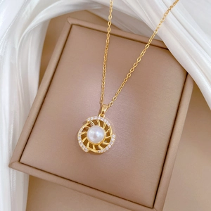 Close-up of a gold-plated pearl pendant with pavé crystals on elegant white silk fabric