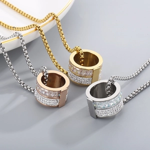 Detailansicht quadratischer Boxketten mit diamantbesetzten Zylinderanhängern in Gold und Silber