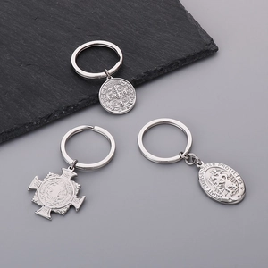 Close-up of stainless steel religious charms with Saint Christopher and cross engravings
