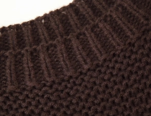 Detailed close-up of dark brown ribbed knit fabric showing high-quality texture