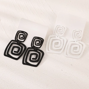 Detail of geometric double spiral square earrings in matte black and white finish