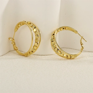 Detail of gold double-layer hoop earrings with geometric textured metal beads