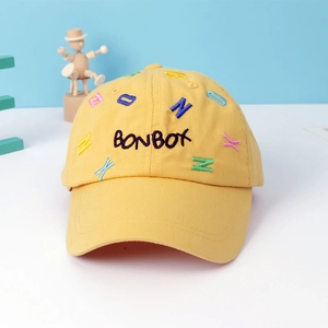 Detail view of yellow cotton kids cap with colorful Bonbox letter embroidery