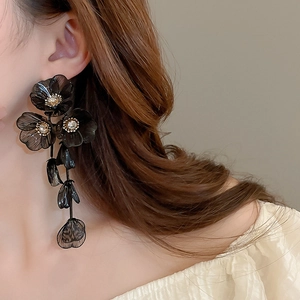 Detail of long floral drop earrings with black translucent petals and sparkling zircons