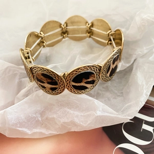 Detail of leopard print metal stretch bracelet with gold textured round settings