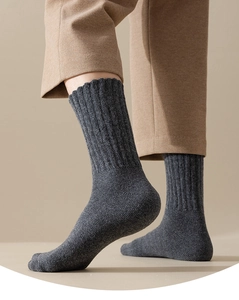 Close-up of gray ribbed knit wool socks worn by model for winter thermal comfort