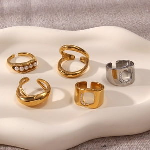 Dettaglio del set di 5 anelli minimalisti con perle e zirconi su vassoio ruvido