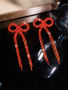 Detailed view of red rhinestone bow tassel earrings with a sparkling luxury finish