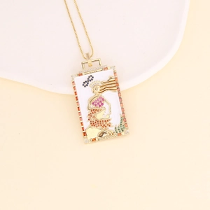 Detail of 18K gold tarot pendant necklace with multicolored zircons and LA FORZA engraving