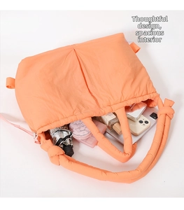 Orange quilted puffer tote bag detail showing large capacity for daily essentials