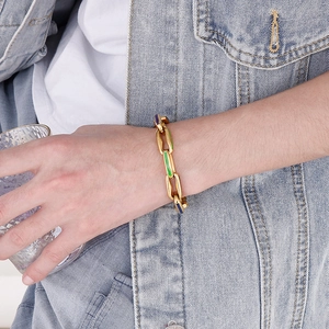 Detail of gold Cuban link bracelet with colorful enamel accents on model wrist