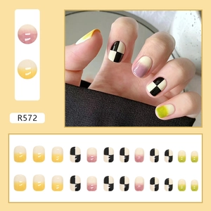 Detail of 24pcs press-on nails with checkerboard and gradient designs in a box