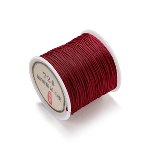 Close-up of 0.8mm dark red braided nylon cord spool for DIY jewelry making and knots