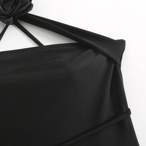 Detail of black bikini top featuring halter straps and a 3D fabric rose decoration