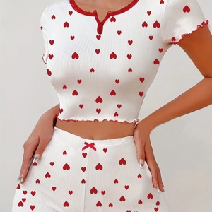 Detailed view of white ribbed knit pajama set with red heart print and lace trim edges