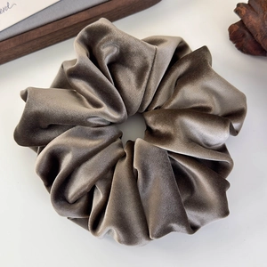 Detailed view of the oversized gray velvet scrunchie showing plush texture and elastic band