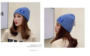 Detail of blue knitted beanie featuring a textured ribbed pattern and stitched textile label