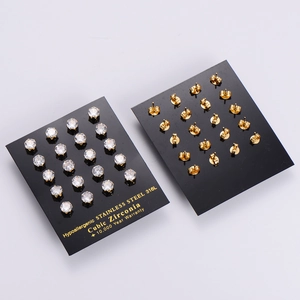 Vue à plat de 20 paires de boucles d'oreilles en acier inoxydable doré avec zircons cubiques