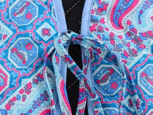 Close-up of quilted floral paisley pattern cotton vest featuring front tie closure