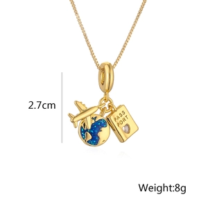 Detail of gold necklace featuring passport, globe, and airplane charms with crystal