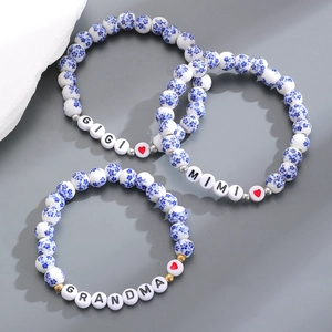Dettaglio di tre braccialetti in ceramica blu con scritte GIGI MIMI GRANDMA e cuori