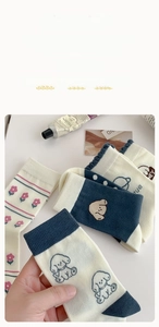 Détail de chaussettes en coton doux avec motifs de chiens bleus et fleurs roses