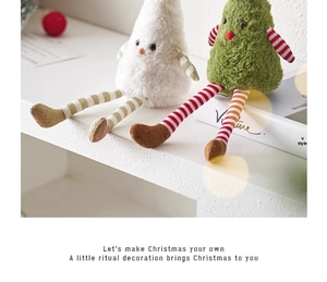 Close-up of plush Christmas tree dolls in white and green with long striped legs