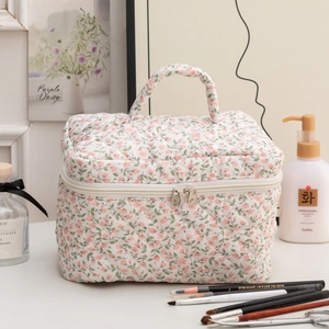 Detailed macro view of floral quilted toiletry bag with premium metal dual zippers