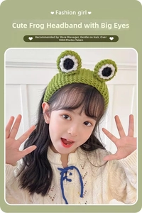 Detailed knit texture of a green frog headband on a child with big handmade eyes