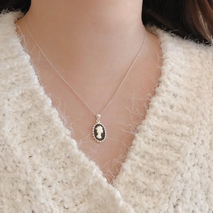 Detail of a vintage 925 silver cameo necklace with a white relief on black background