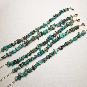Detailed view of bohemian natural turquoise chip bracelets with gold lobster clasps