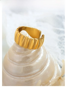 Macro detail of gold textured wavy ring on a pearl seashell with elegant lace background