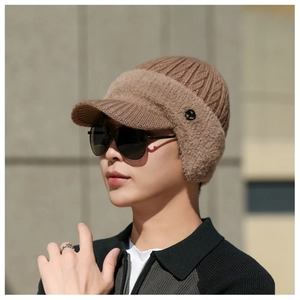 Detail of warm brown knit winter hat with fleece ear flaps and visor for men