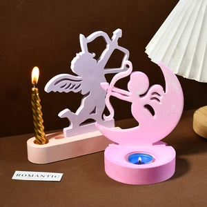 Detailansicht der Amor-Engel-Kerzenhalter mit goldenen Spiralkerzen und warmem Licht