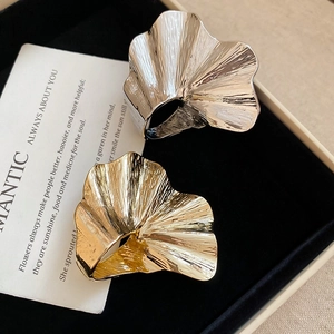 Detail of silver and gold ginkgo leaf rings with unique metallic pleated textures