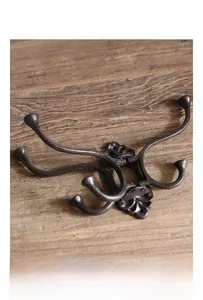 Detailed close-up of retro cast iron wall hook with industrial texture on vintage wood
