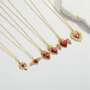 Detailed view of six gold necklaces featuring red heart pendants with angel wing and crown accents