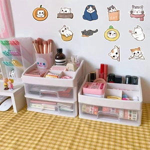 White plastic desk organizer drawers on yellow checkered fabric with cute cat stickers