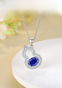 Macro shot of S925 silver tanzanite gourd pendant on a white ceramic plate
