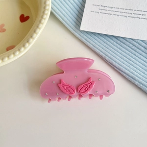 Elegant pink wing hair claw clip with rhinestones and translucent resin finish