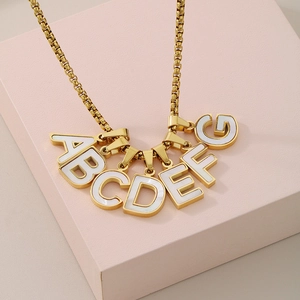 Elegant 18K gold plated necklace featuring white shell letter pendants on pink cubes