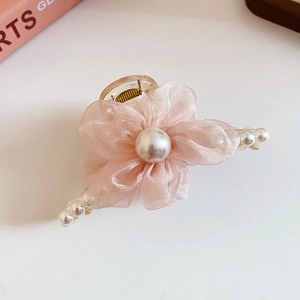 Detail of pink mesh flower hair claw clip with pearl accents and elegant design