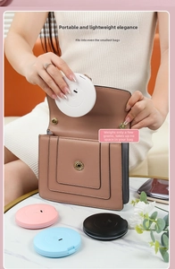 Close-up of a portable ultra-thin round LED makeup mirror being placed into a small bag
