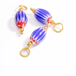 Detailed macro view of colorful Chevron glass bead with polished golden metal ring clasp