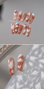 Detailed view of 3D embossed white floral and butterfly nail art stickers on pink base