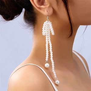 Detailed side view of long pearl tassel earrings worn on a model for a stylish look