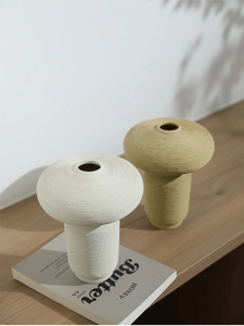 Detalle de jarrones de cerámica con forma de hongo y textura cepillada sobre madera