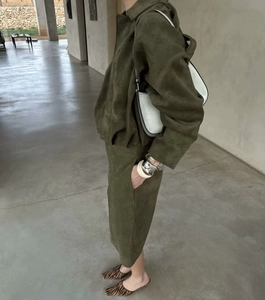 Side view of olive suede jacket and matching long skirt set on a fashion model